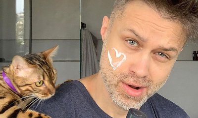 Maciej Zakościelny miesza sałatkę w fartuszku i czapce. Tylko w fartuszku i czapce
