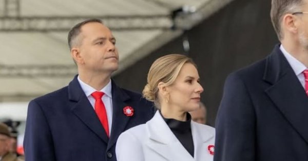 Marta Nawrocka na obchodach 11 listopada w białym dwurzędowym płaszczu i czarnych dodatkach