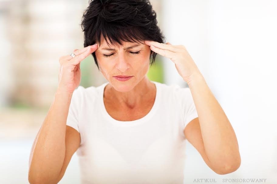 mid age woman having headache and massaging forehead