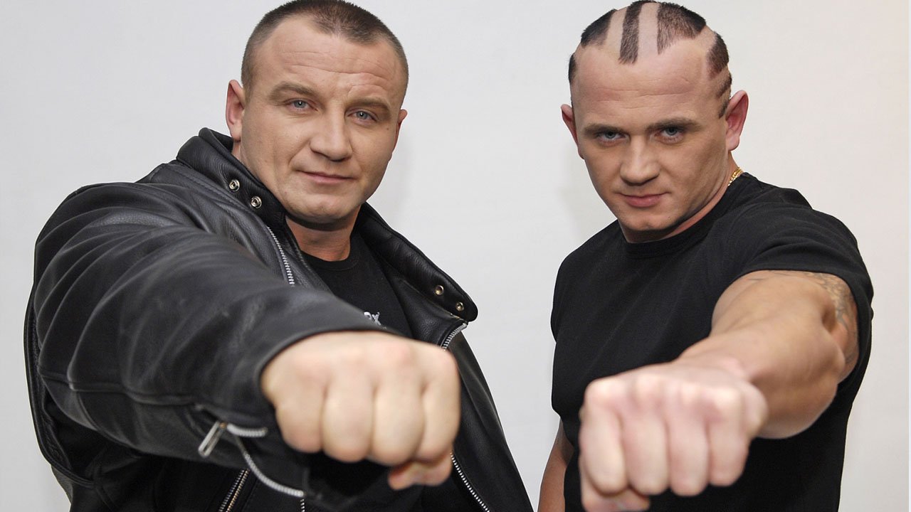 Mariusz Pudzianowski w zaczesanych do tyłu blond włosach. Wygląda jak James Bond