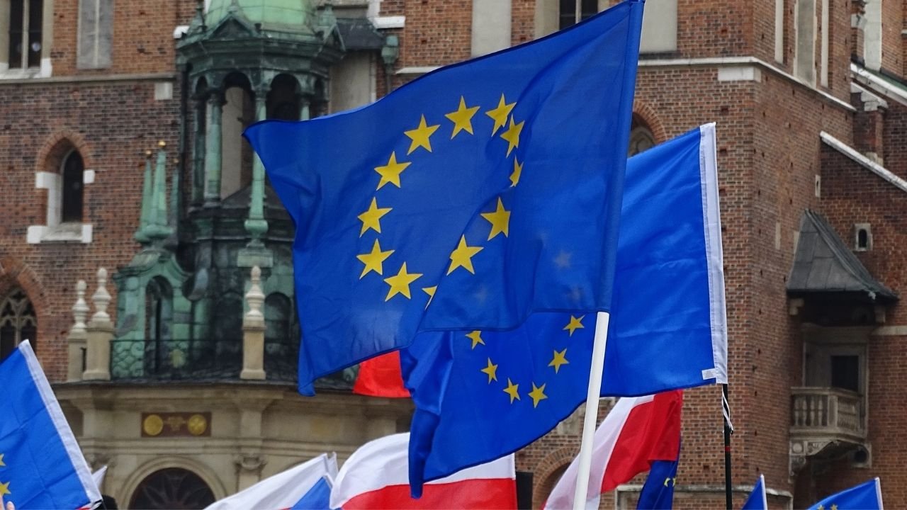 Flaga Unii Europejskiej oraz Polski na tle Kościoła Mariackiego w Krakowie