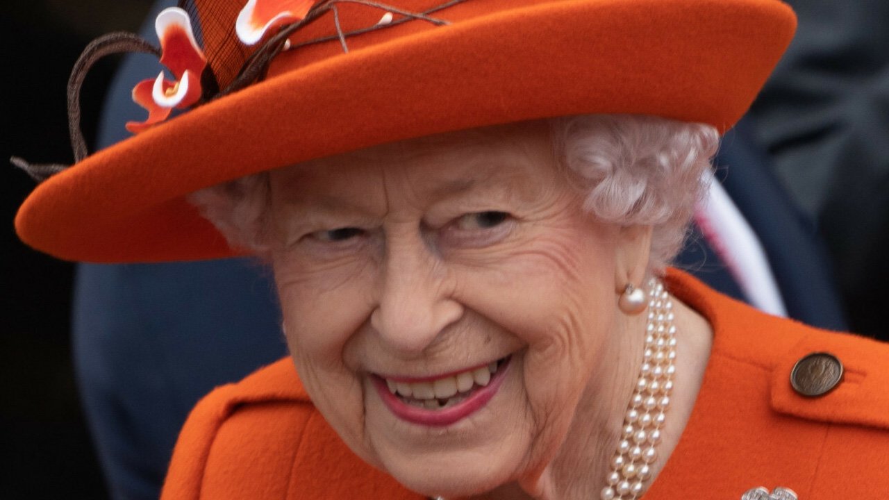 Królowa Elżbieta II w czerwonym kapeluszu i płaszczu