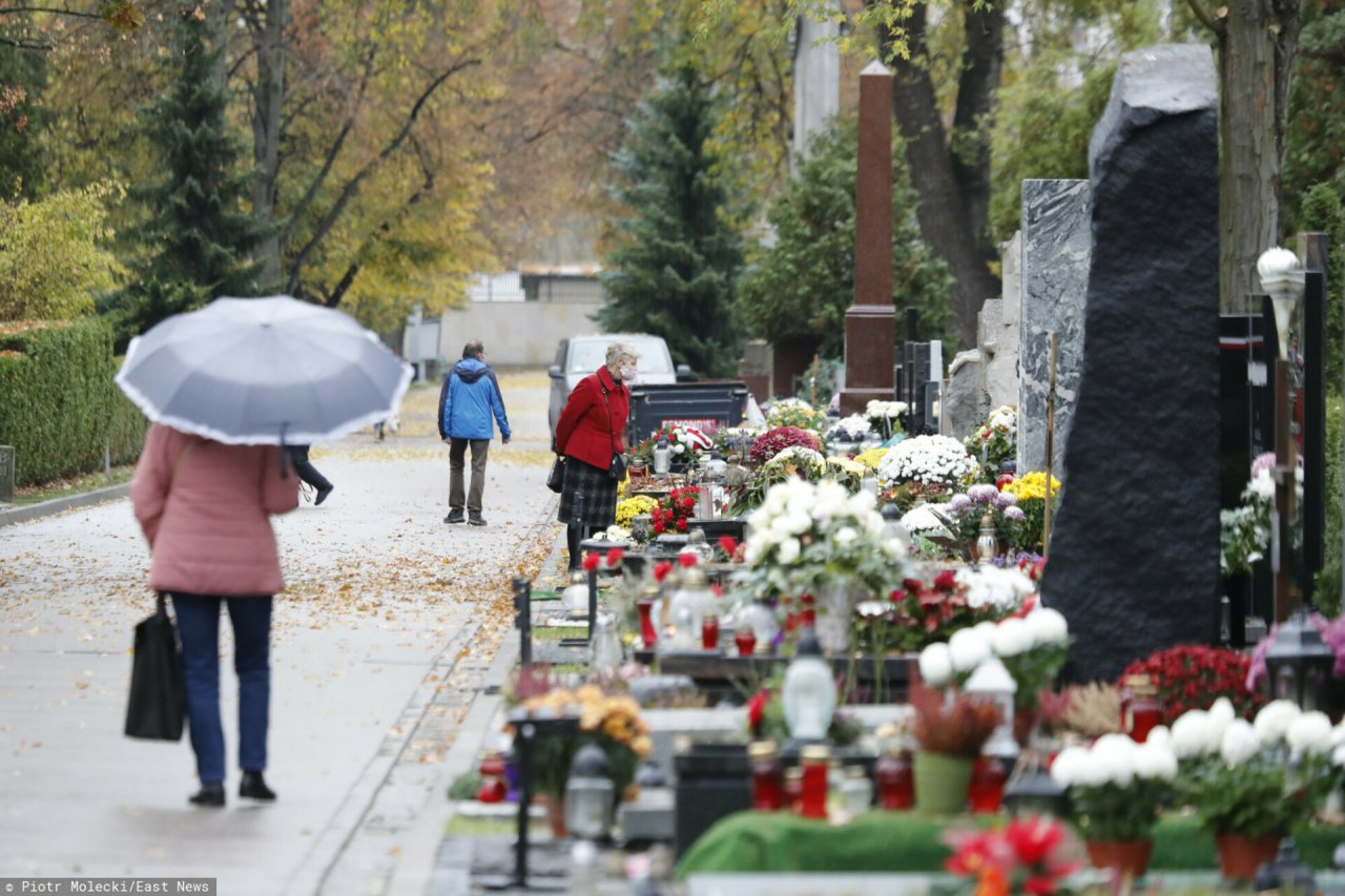 zdjęcie cmentarza z idącymi ludźmi 