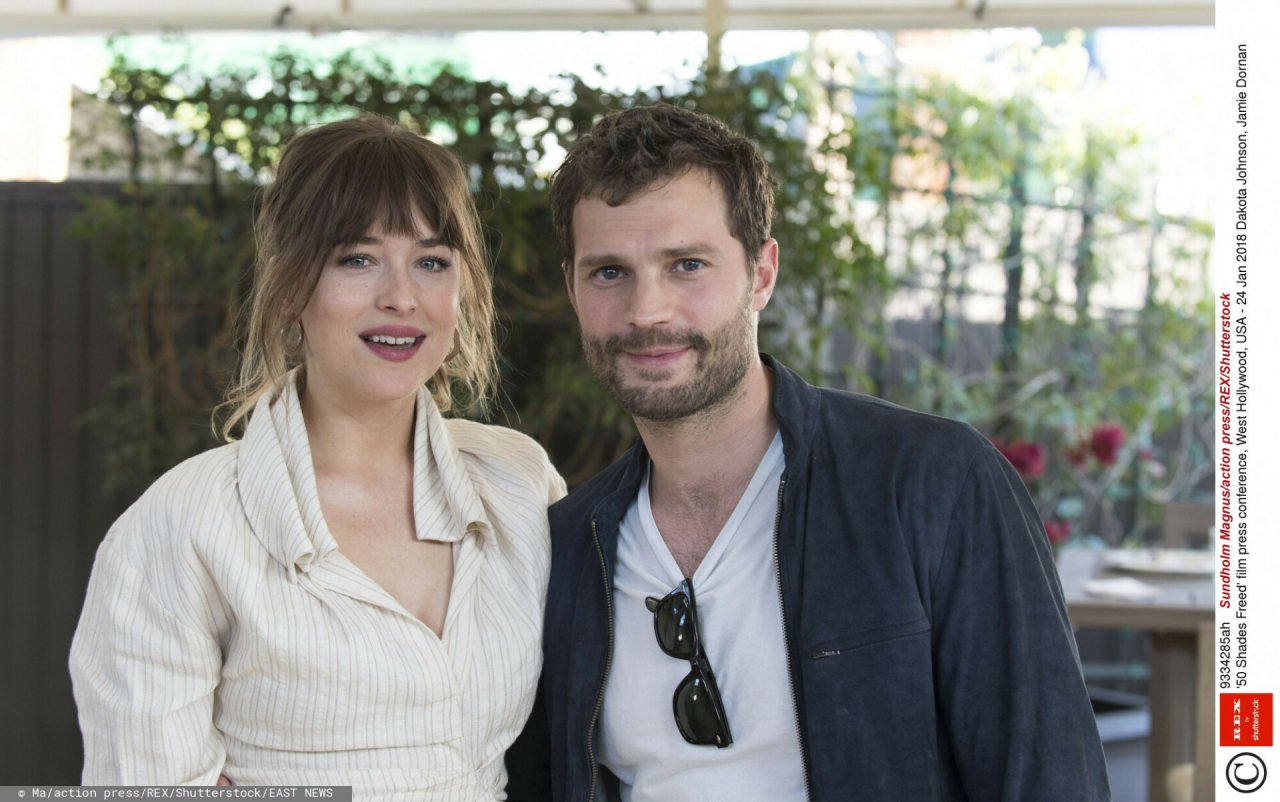 Dakota Johnson na biało siedzi wtulona w Jamiego Dornana
