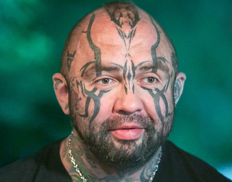 Marcin "Różal" Różalski uśmiecha się delikatnie a w tle widać rośliny