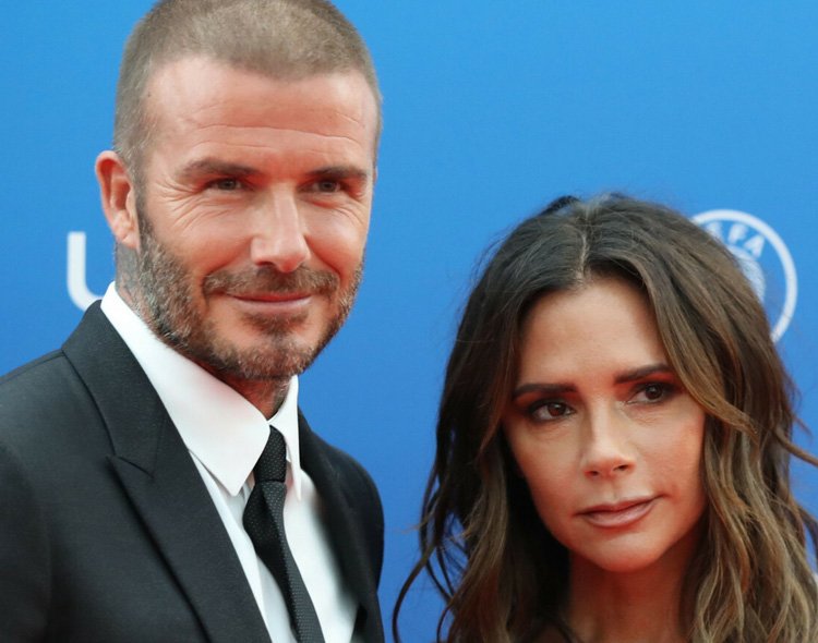 Victoria Beckham i David Beckkham na niebieskim tle
