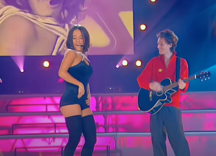 Alizee w czarnej mini i butach za kostkę tańczy na scenie