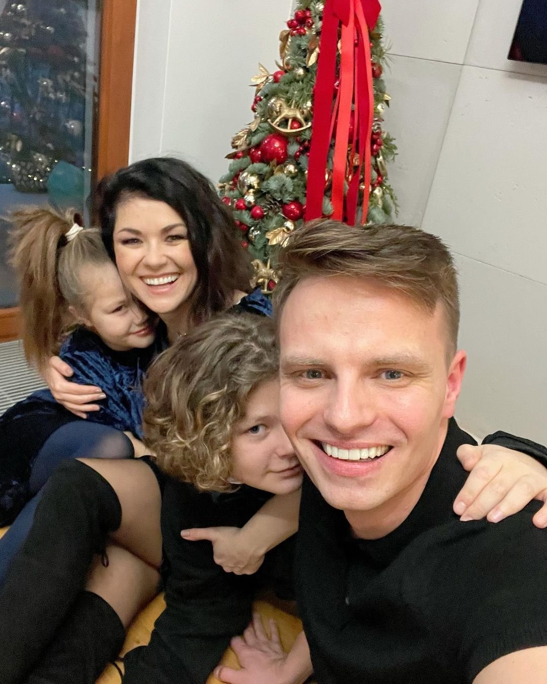 Katarzyna Cichopek przytula córkę, syna oraz męża, Marcina Hakiela, a w tle choinka