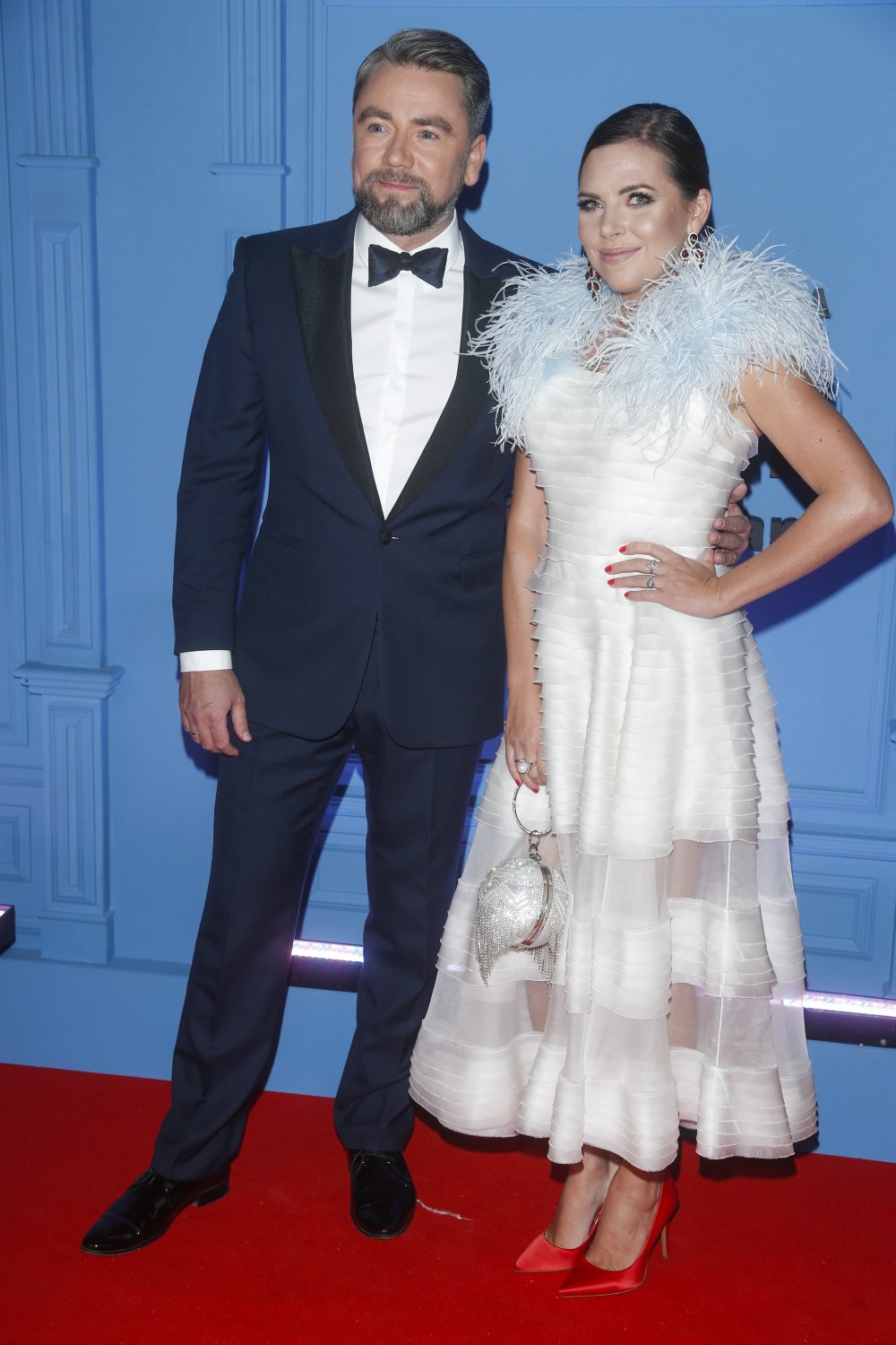 Aleksandra Kwaśniewska w białej sukni z piórami oraz Kuba Badach w garniturze