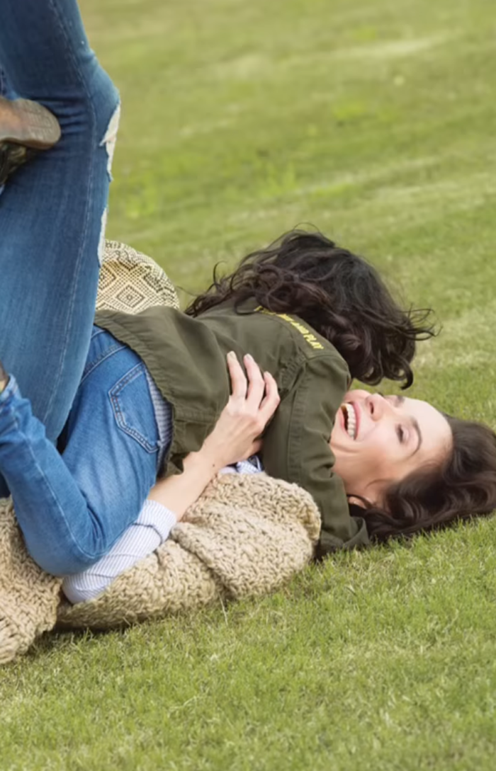 Natalia Oreiro obejmuje syna, leżąc na zielonej trawie