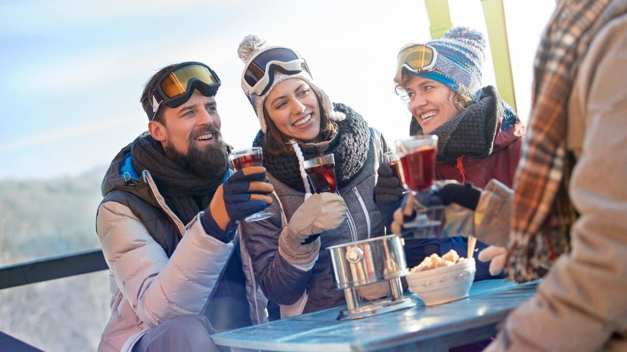 Narciarze odpoczywają przy herbacie w ubraniach w stylu apres-ski