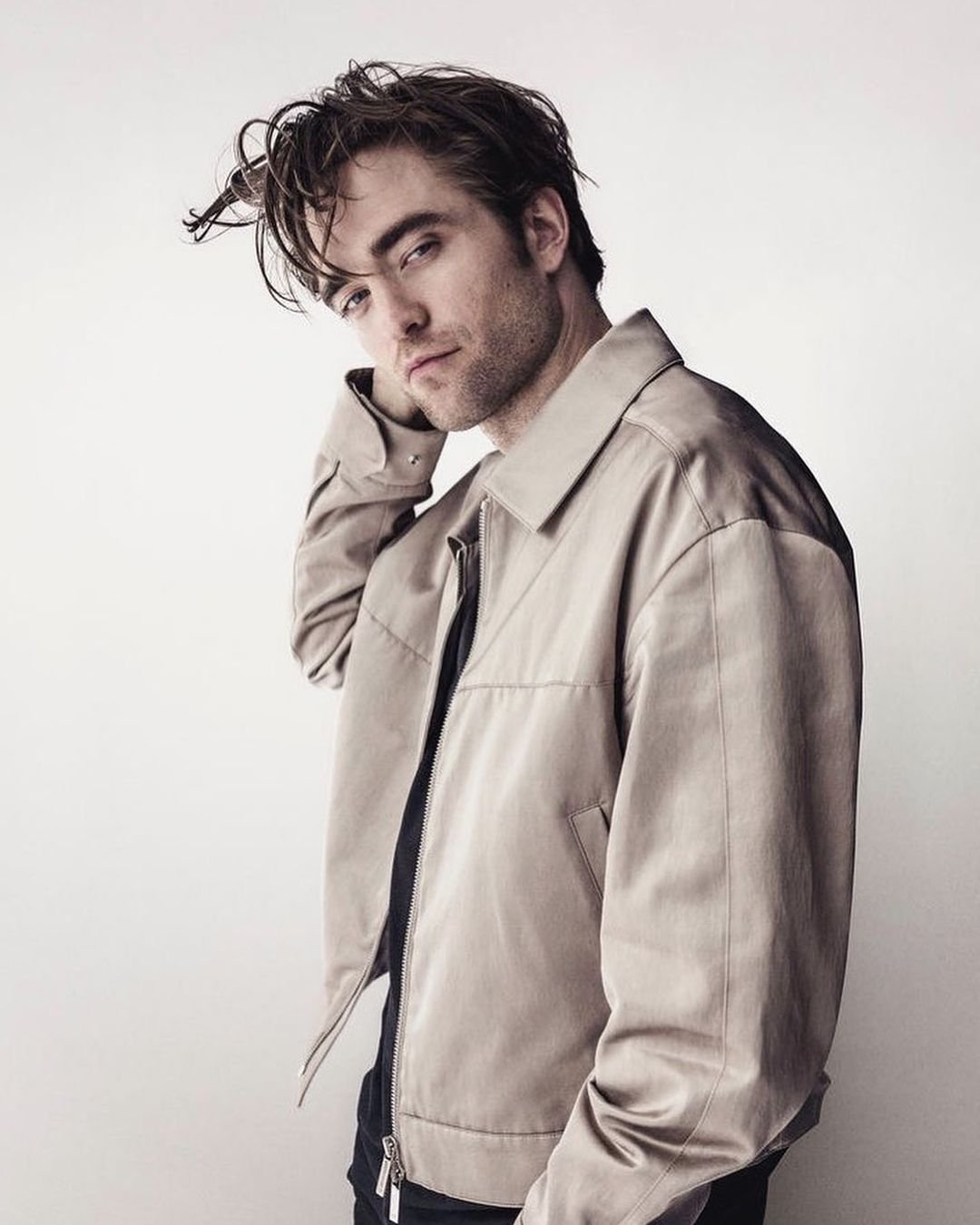 Robert Pattinson pozuje do zdjęcia w bialej kurtce