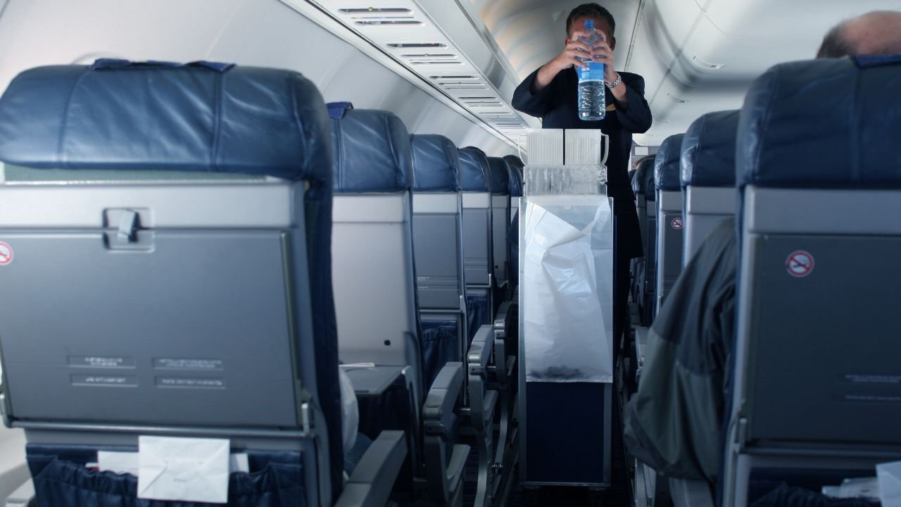 steward w przejściu między siedzeniami w samolocie 