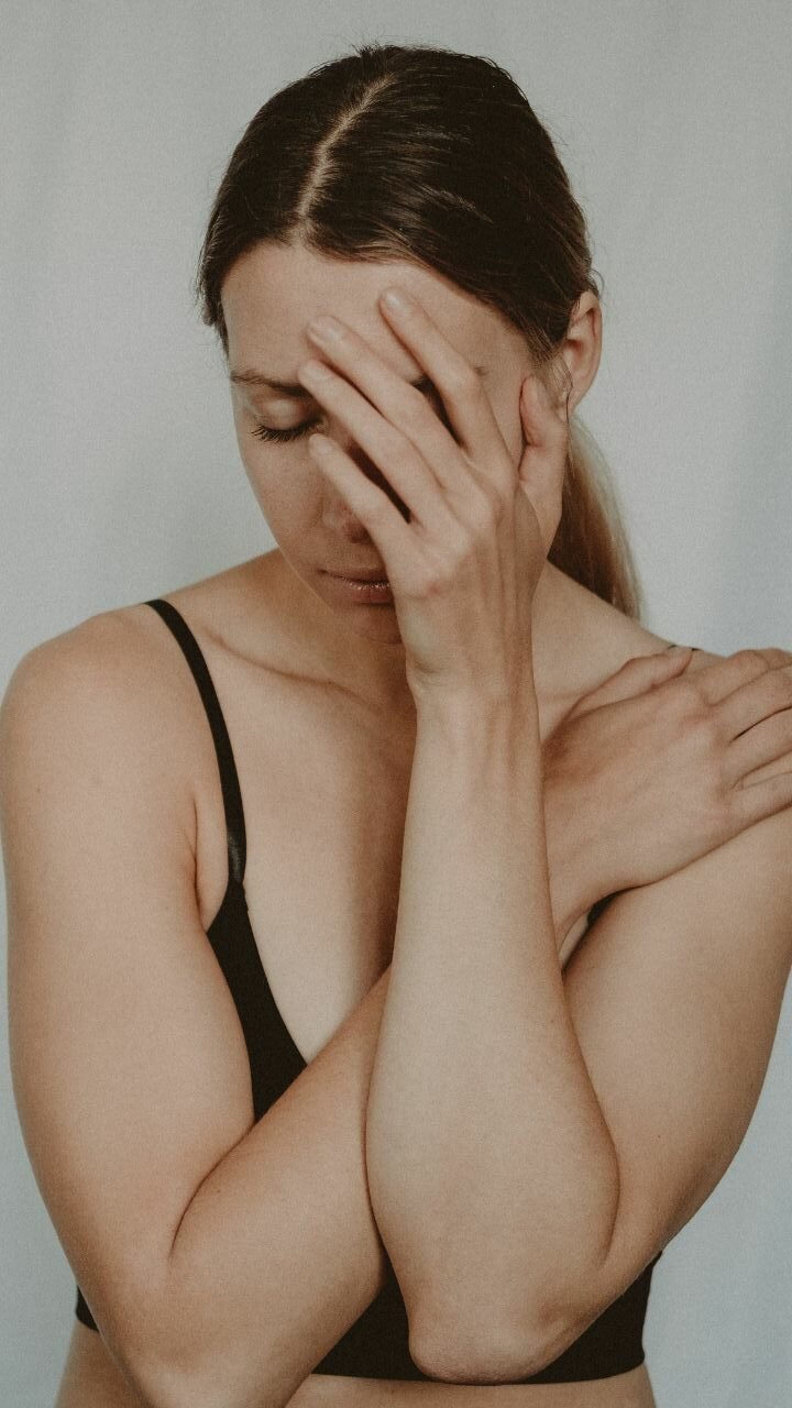 smutna kobieta zakrywająca twarz ręką 