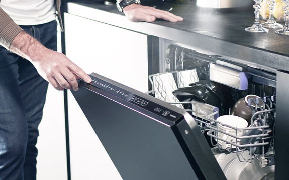 Męska ręka otwierająca Zmywarka Beko DIS 46120 w kuchni