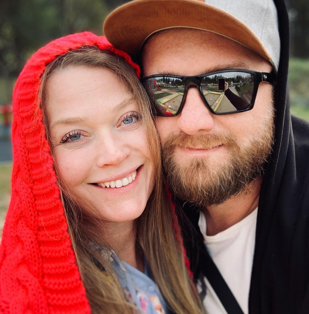Tamara Arciuch w czerwonym kapturze z Kasprzykowskim w czapce zdaszkiem i w okularach słonecznych