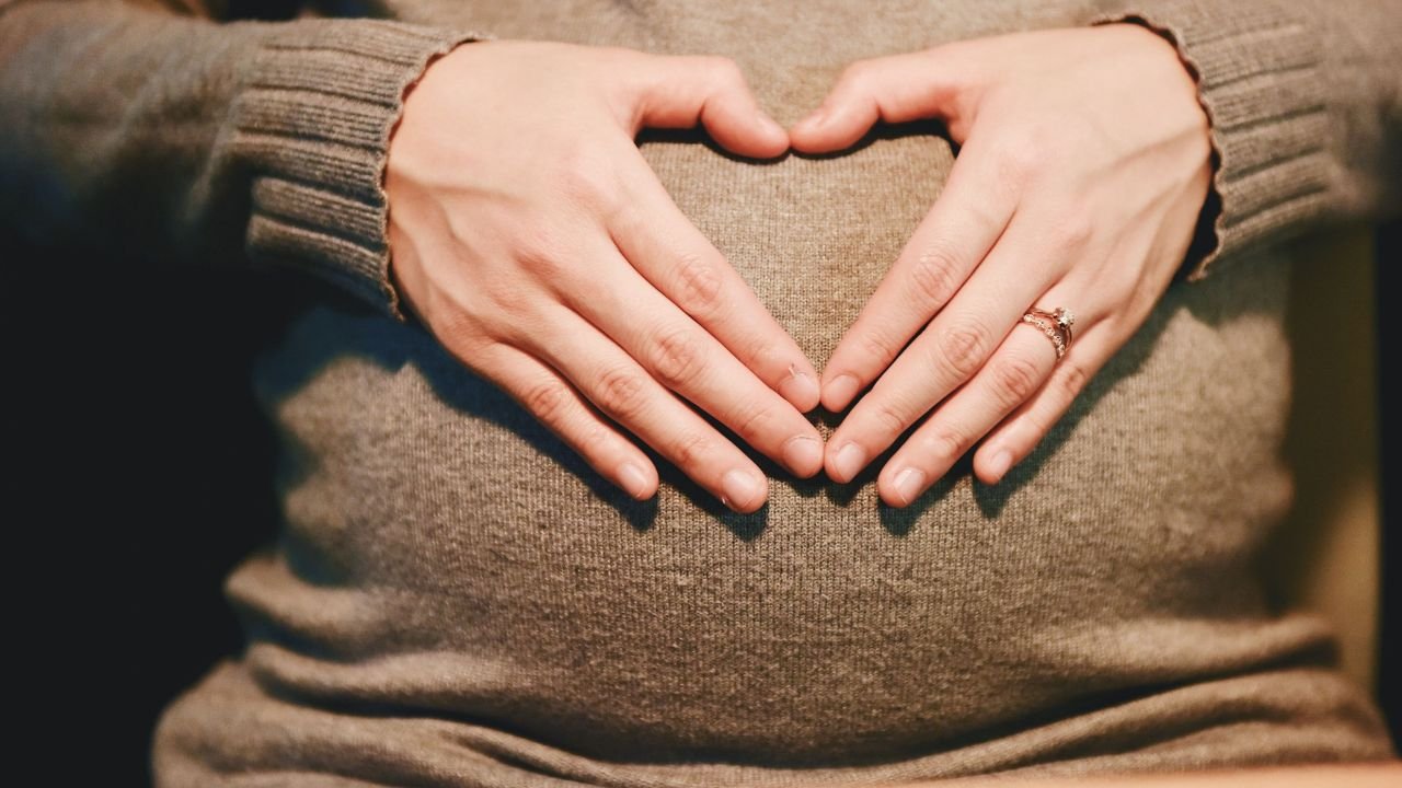 serce ułożone z dłoni na beżowym swetrze