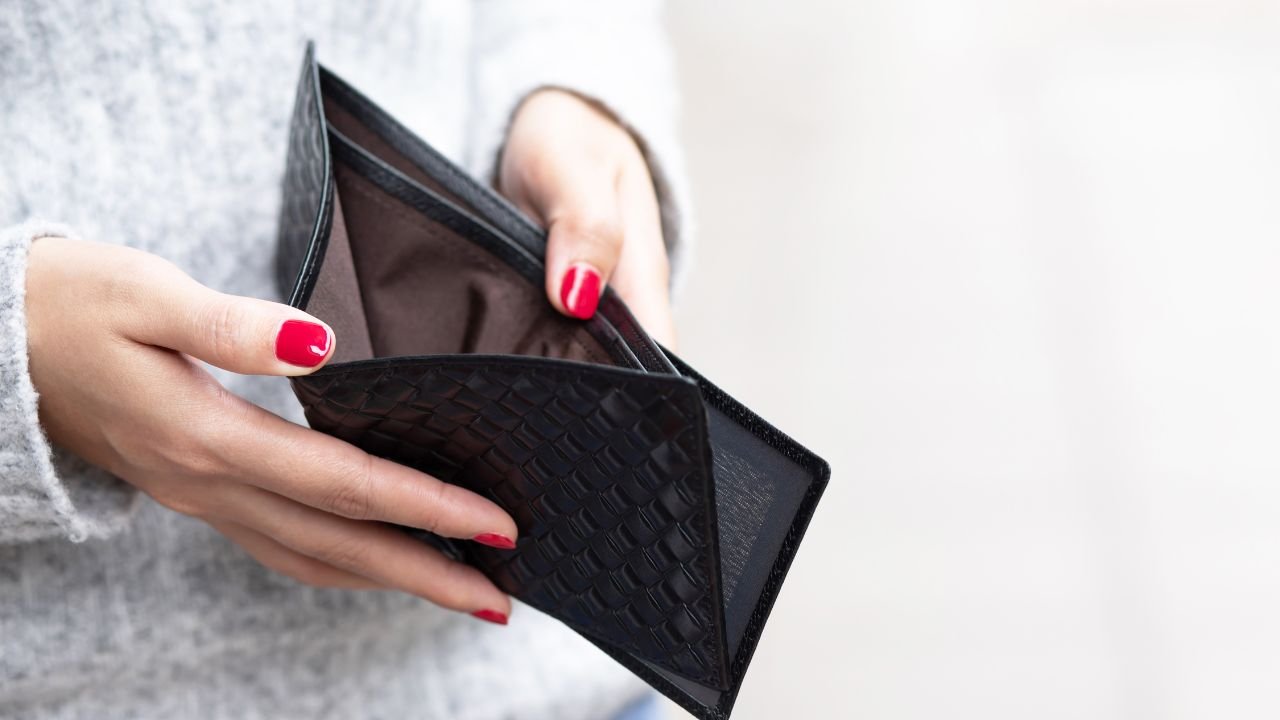 kobieta trzyma czarny portfel w dłoniach 