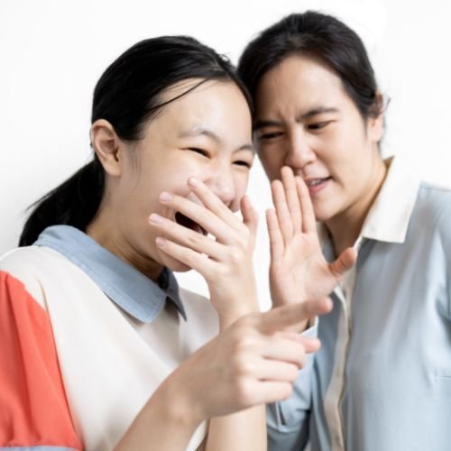 Dwie kobiety wskazują kogoś palcem i się z niego smieją