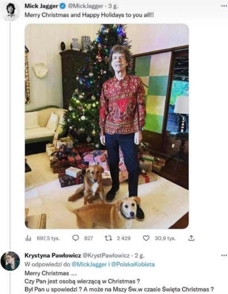 Mick Jagger na tle choinki z dwoma psami