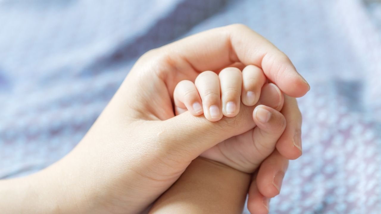 spleciona dłoń mamy i dziecka