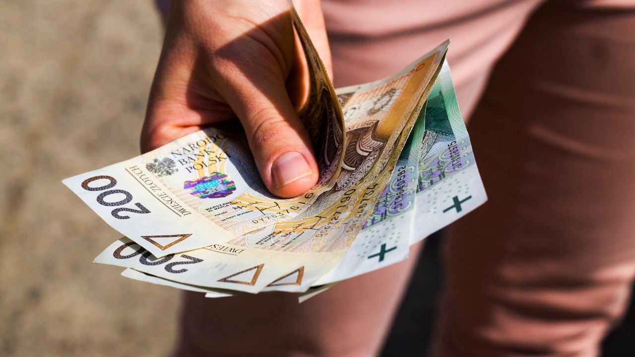 pieniądze trzymane w ręku przez teściową, która daje je na tacę 