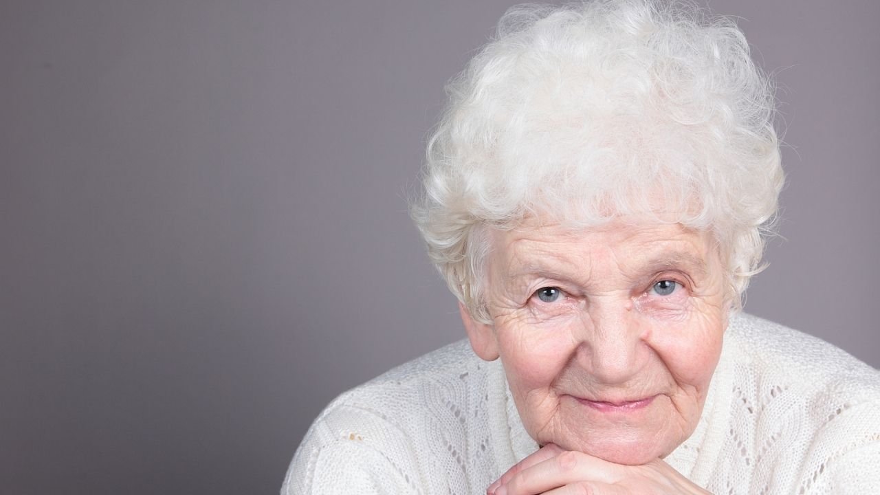 kobieta, babcia z siwymi włosami i delikatnym uśmiechem na twarzy