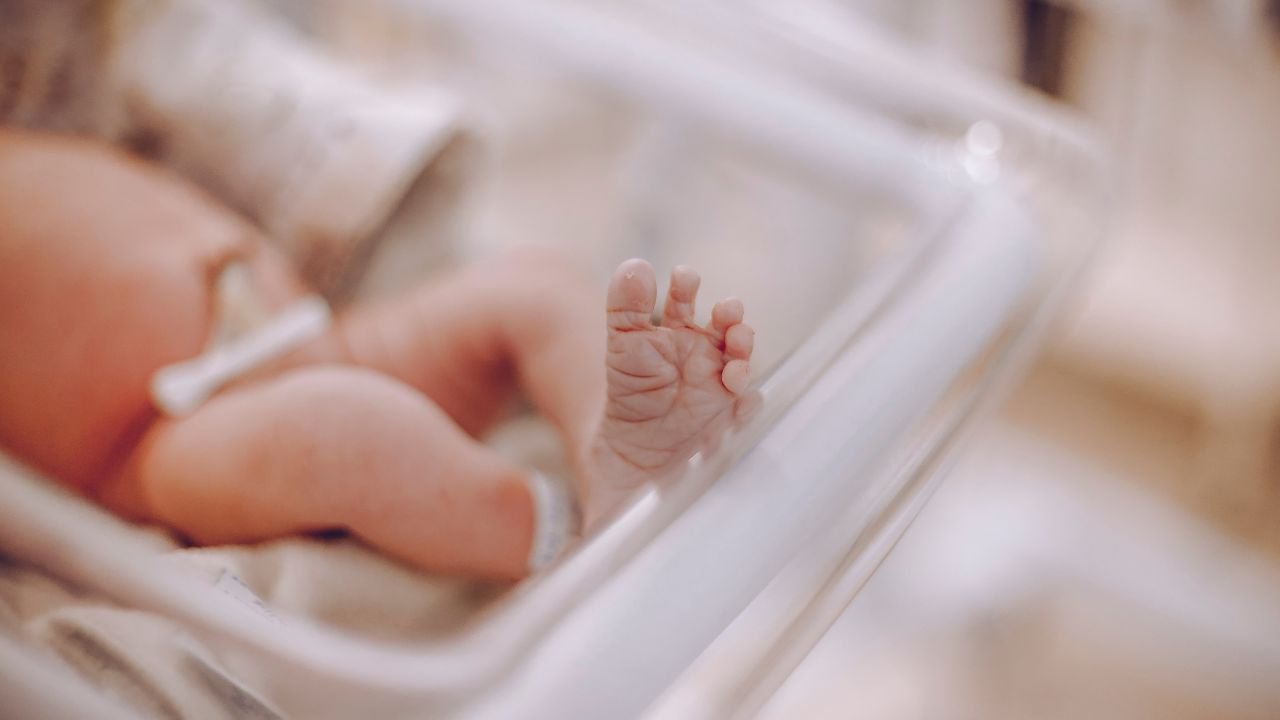 Niemowlę po porodzie w szpitalnym łóżeczku