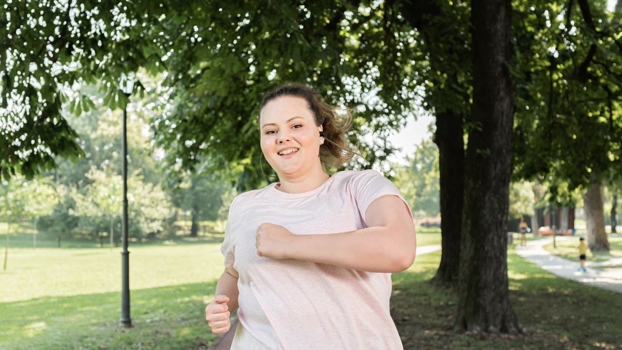 kobieta w szarej koszulce biegnie w parku