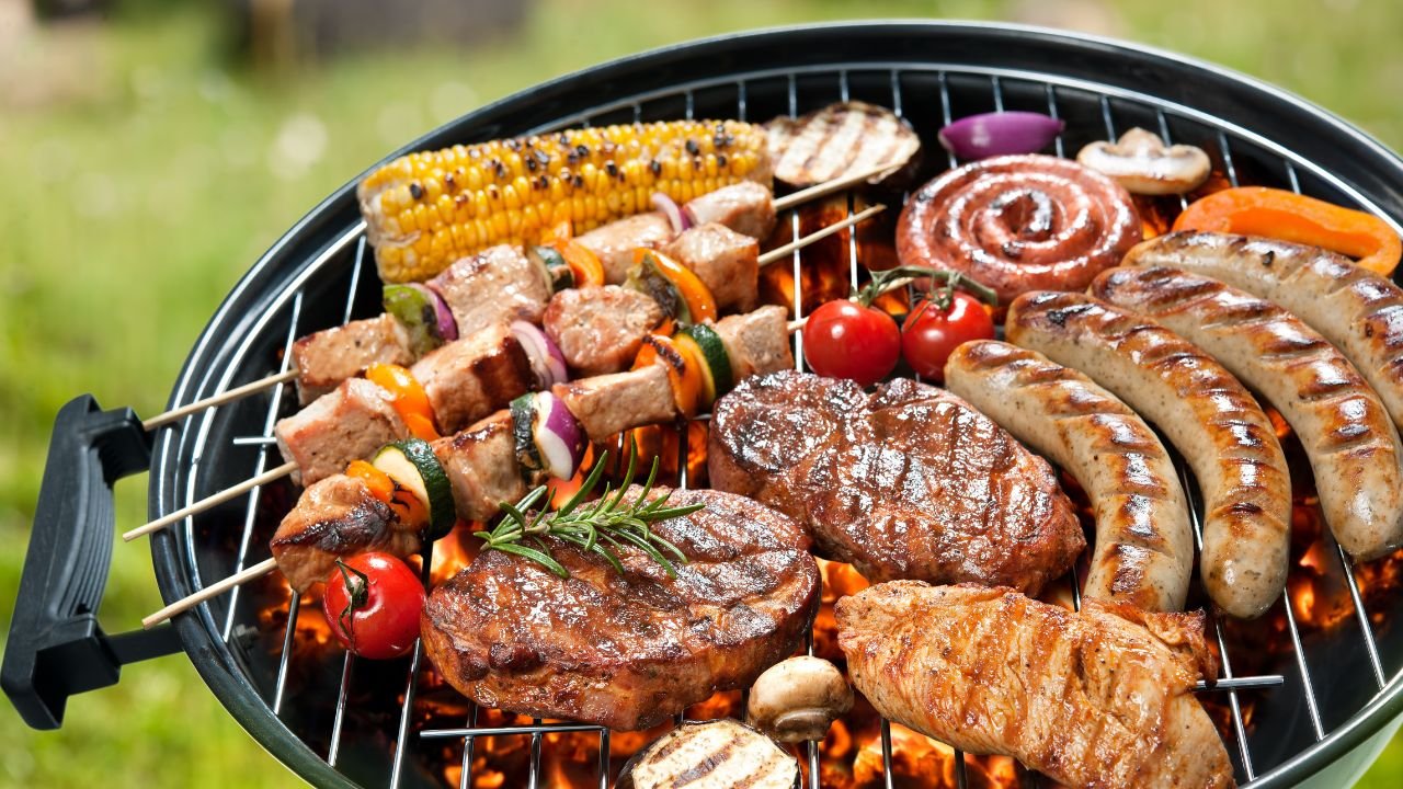 zbliżenie na grill, na którym piecze się mięso oraz warzywa