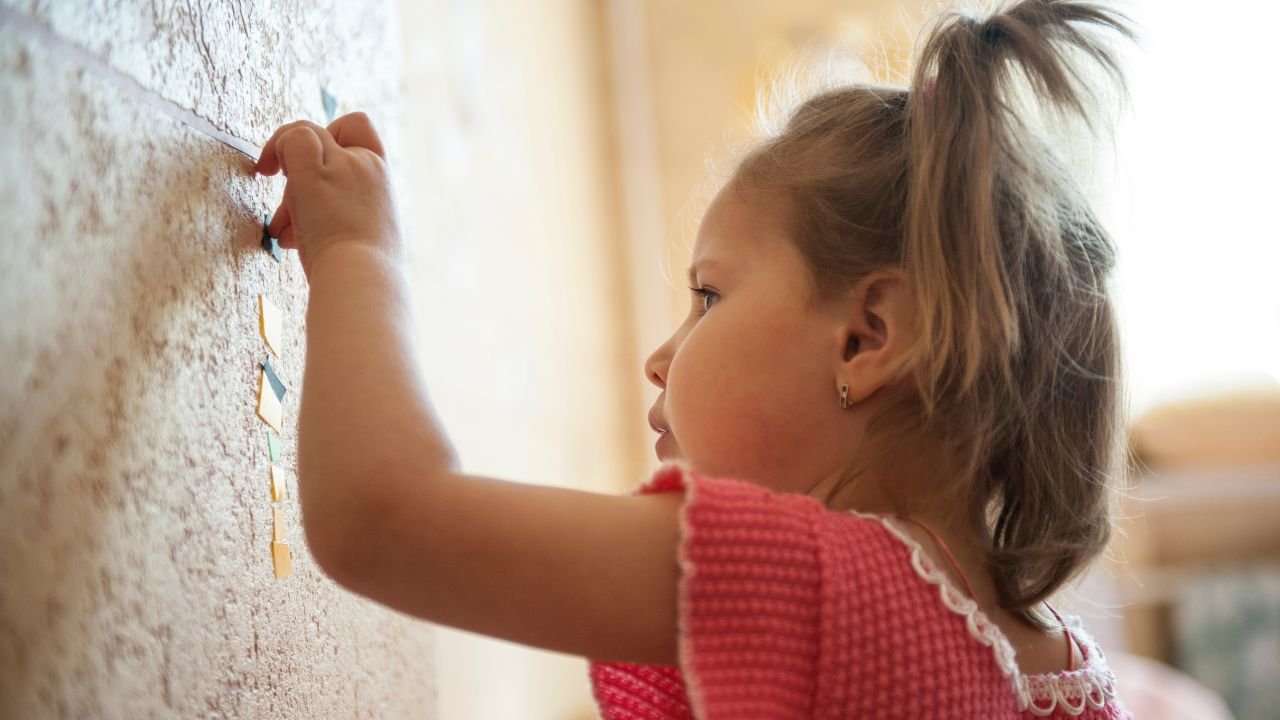trzyletnia dziewczynka pisze po ścianie