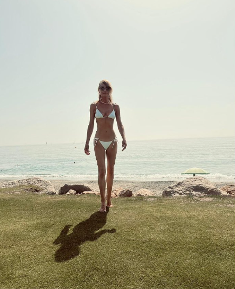 Aneta Kręglicka w białym bikini stoi na tle morza