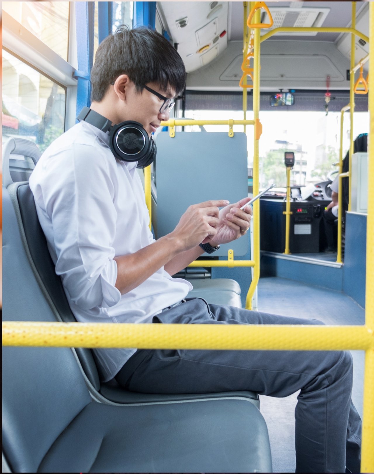 Młody mężczyzna w słuchawkach jadący autobusem