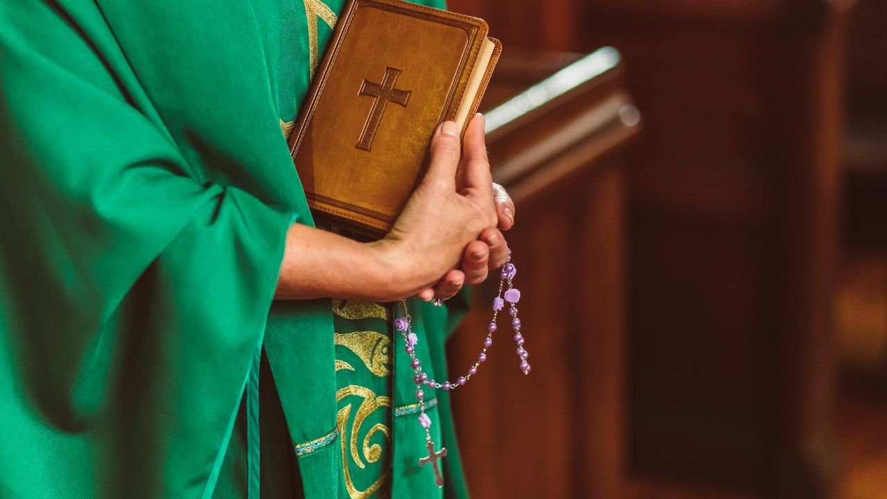 Ksiądz trzyma w ręku Biblię
