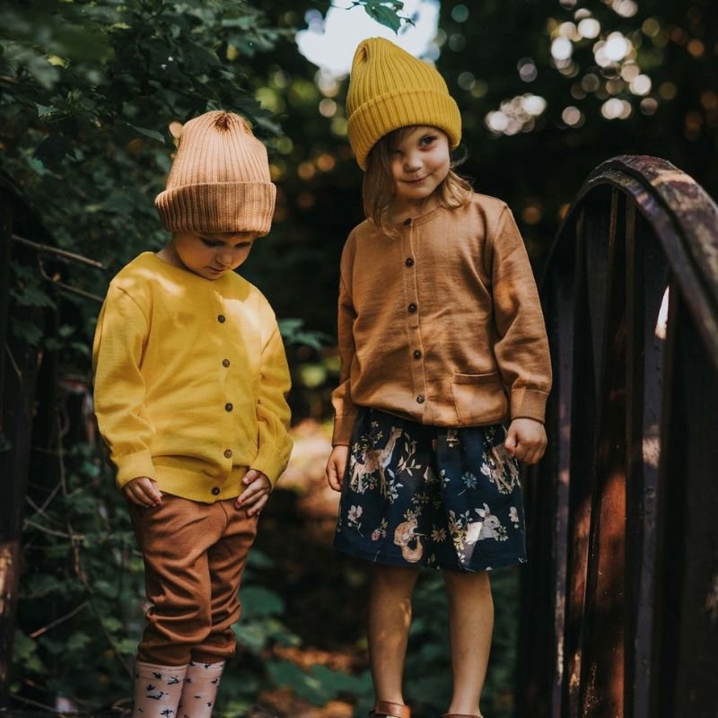 Dzieci w lesie w ubraniach kolorowych z wełny merino gorpcore