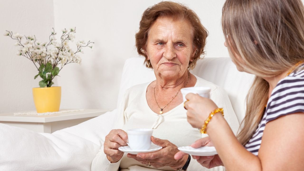 babcia siedzi na kanapie z białą filiżanką