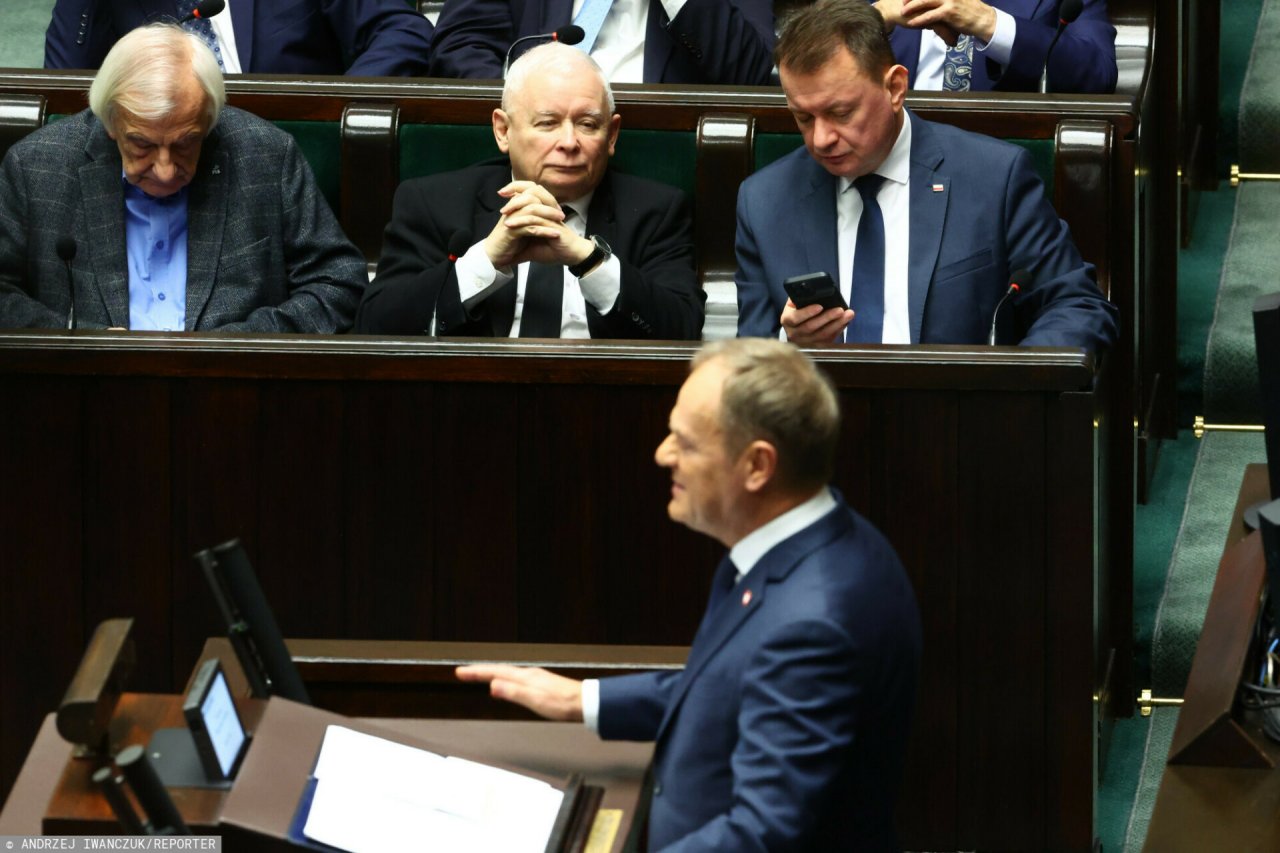Jarosław Kaczyński w czarnym garniturze, smutny, Donald Tusk w granatowym garniturze