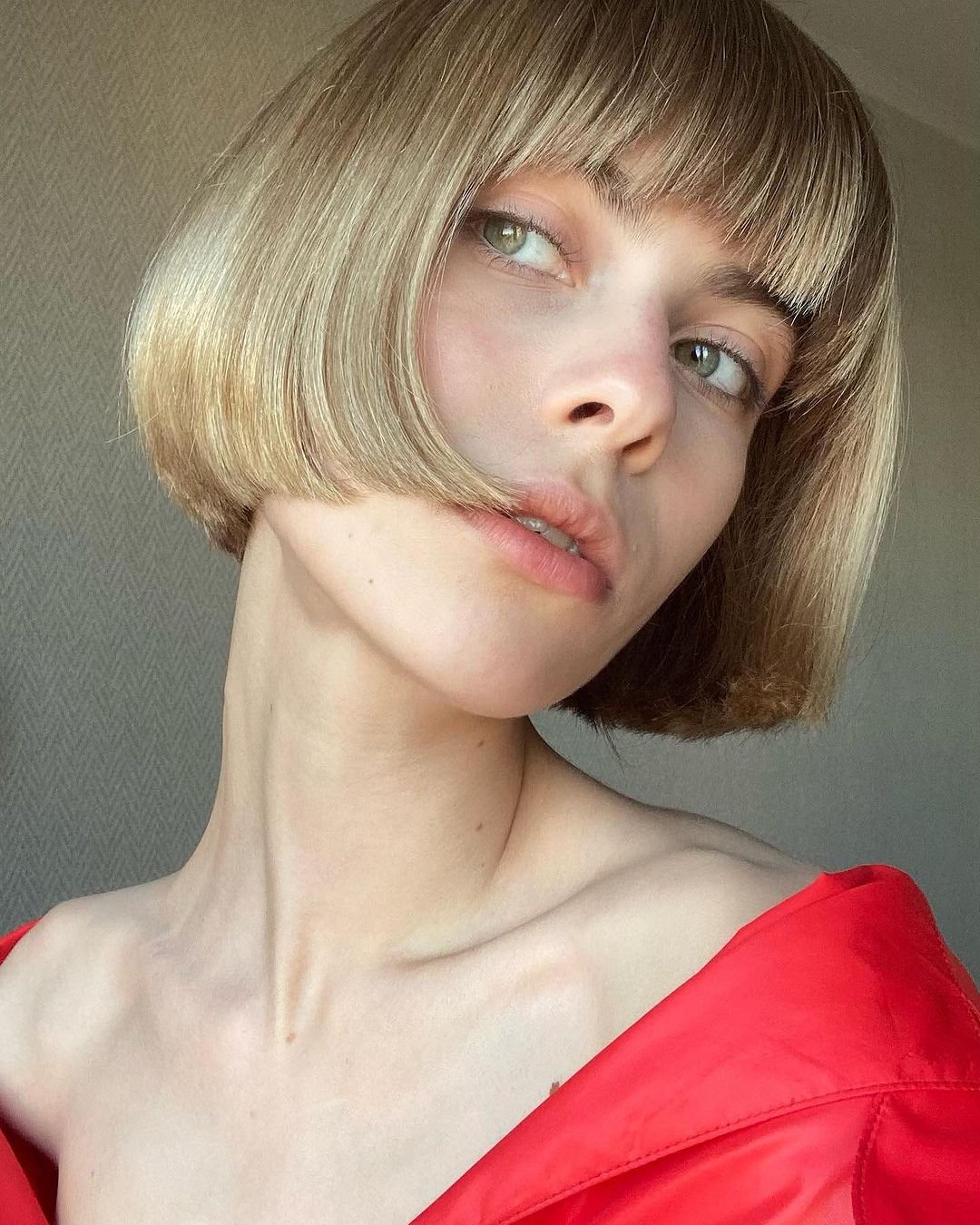 Zbliżenie na twarz kobiety w krótkich blond włosach z grzywką