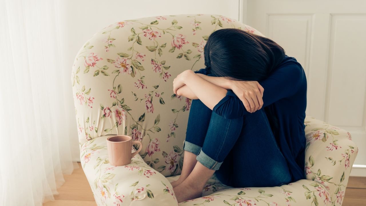 zasmucona dziewczyna siedzi w fotelu