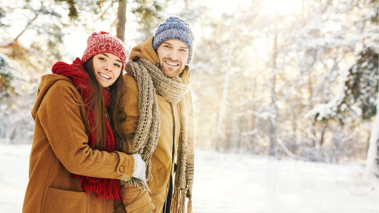Dziewczyna i chłopak w czapkach i szalikach i brązowych kurtkach na zimowym spacerze