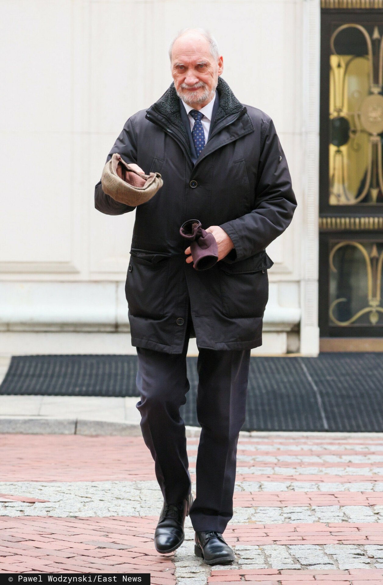 Antoni Macierewicz ściągający kaszkiet z głowy