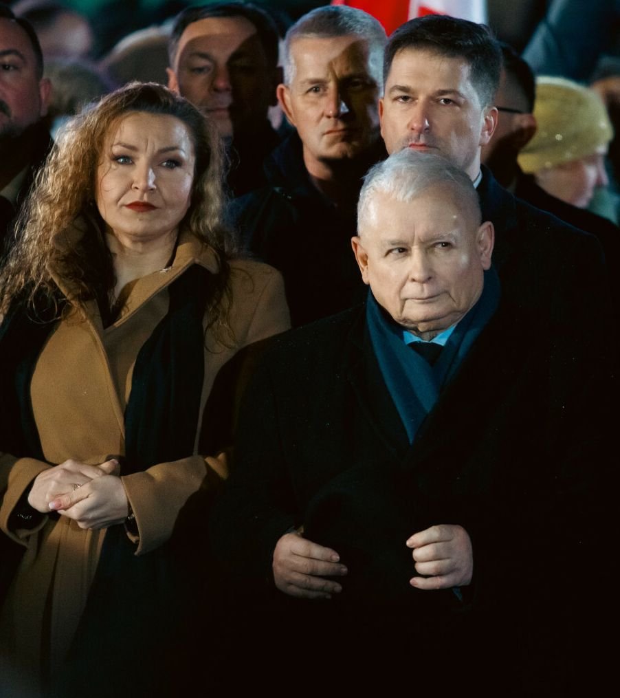 Monika Pawłowska w beżowym płaszczu, stoi obok Jarosława Kaczyńskiego