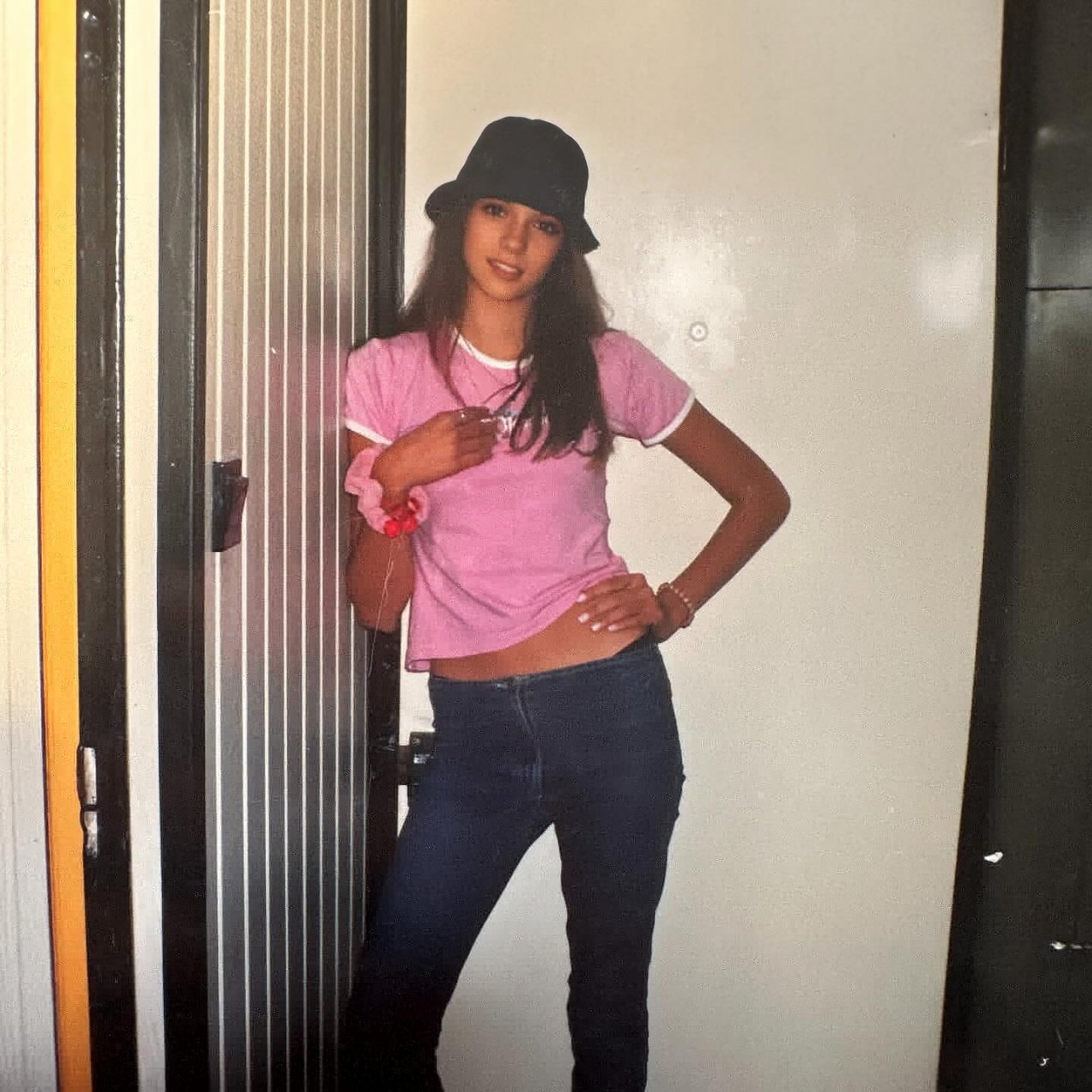 15-letnia Paulina Krupińska w kapeluszu, różowym t-shircie i biodrówkach oparta o drzwi