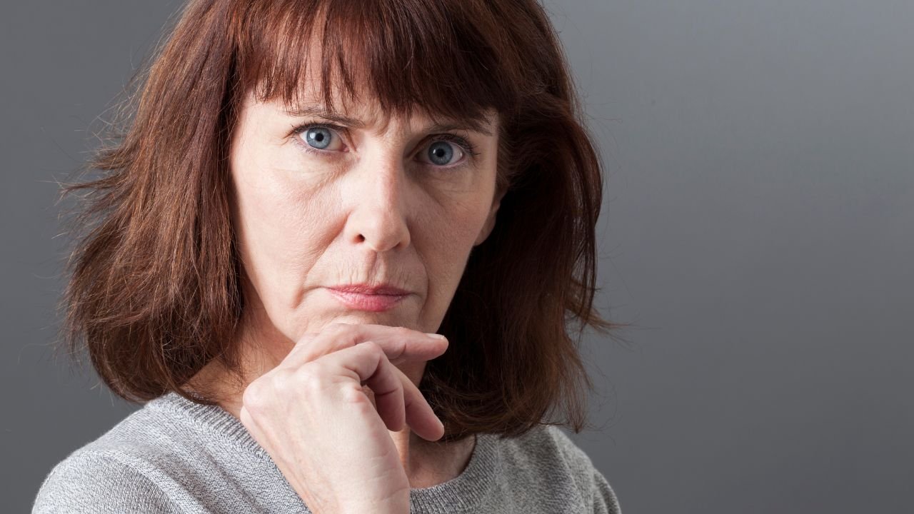 Zbliżenie na poważną minę kobiety.