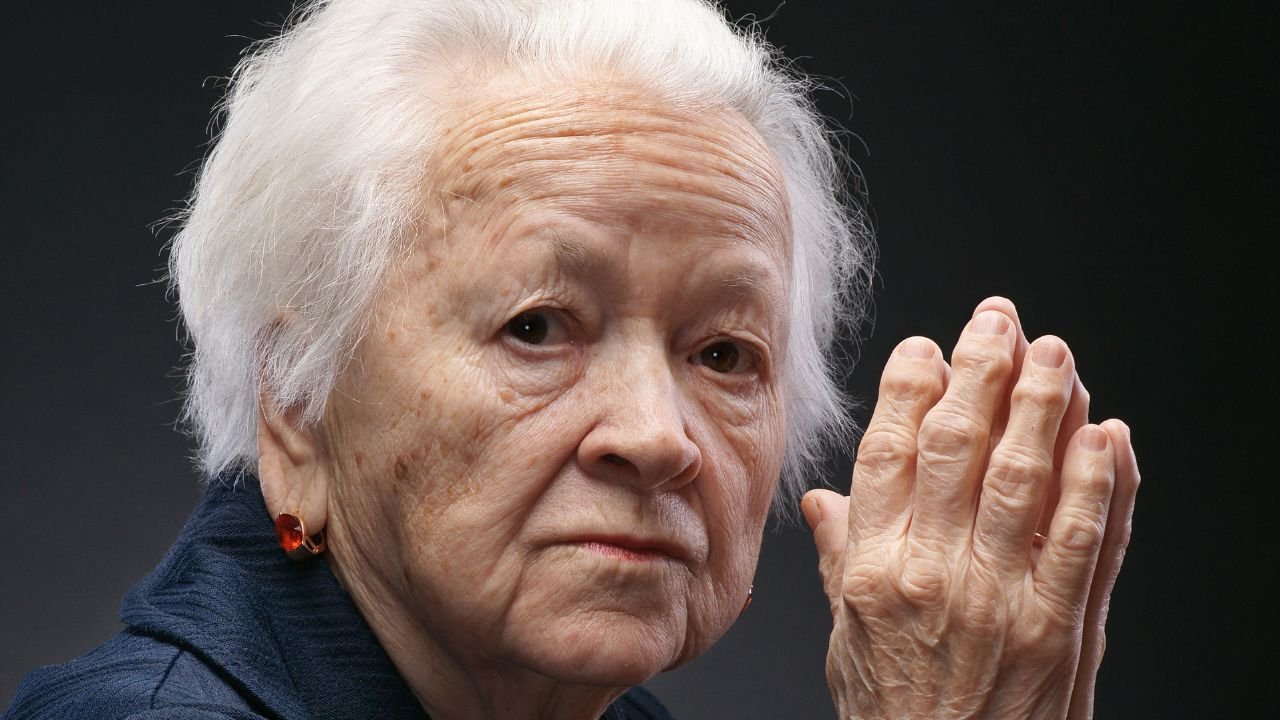 Starsza kobieta ze złożonymi rękami