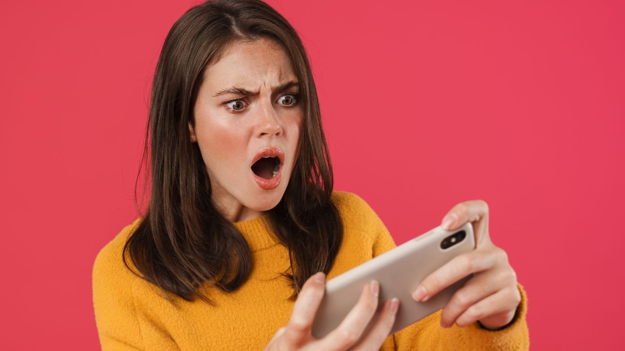 kobieta patrzy na telefon i jest zdziwiona