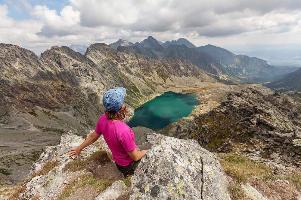 Kobieta odpoczywa siedząc na skale po wycieczce w Tatrach