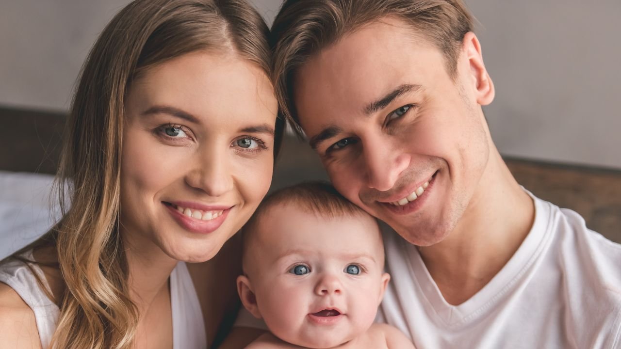kobieta i mężczyzna ubrani na biało z małym dzieckiem