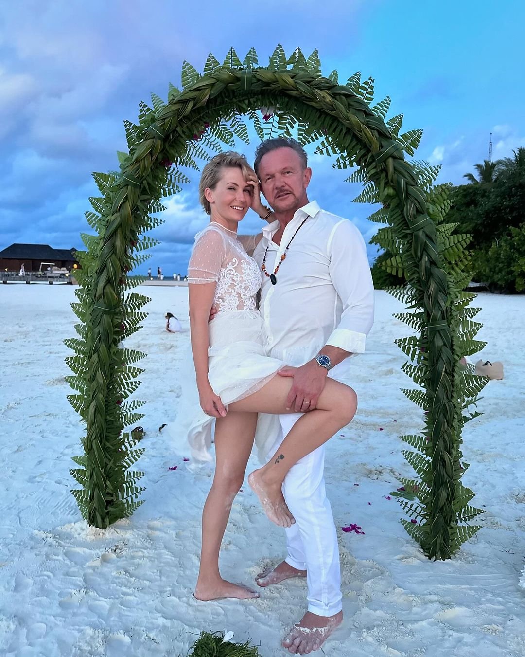 Edyta i Cezary Pazurowie na plaży w białych kreacjach