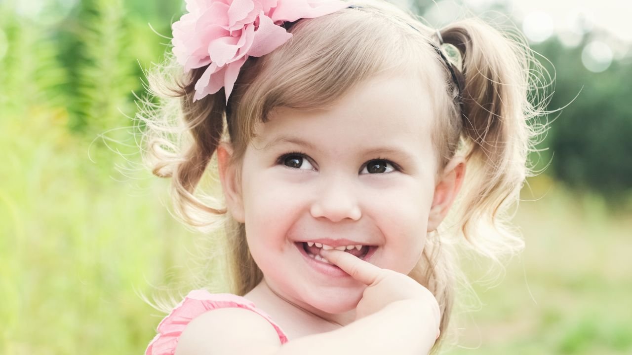 Mała dziewczynka trzyma rękę w buzi